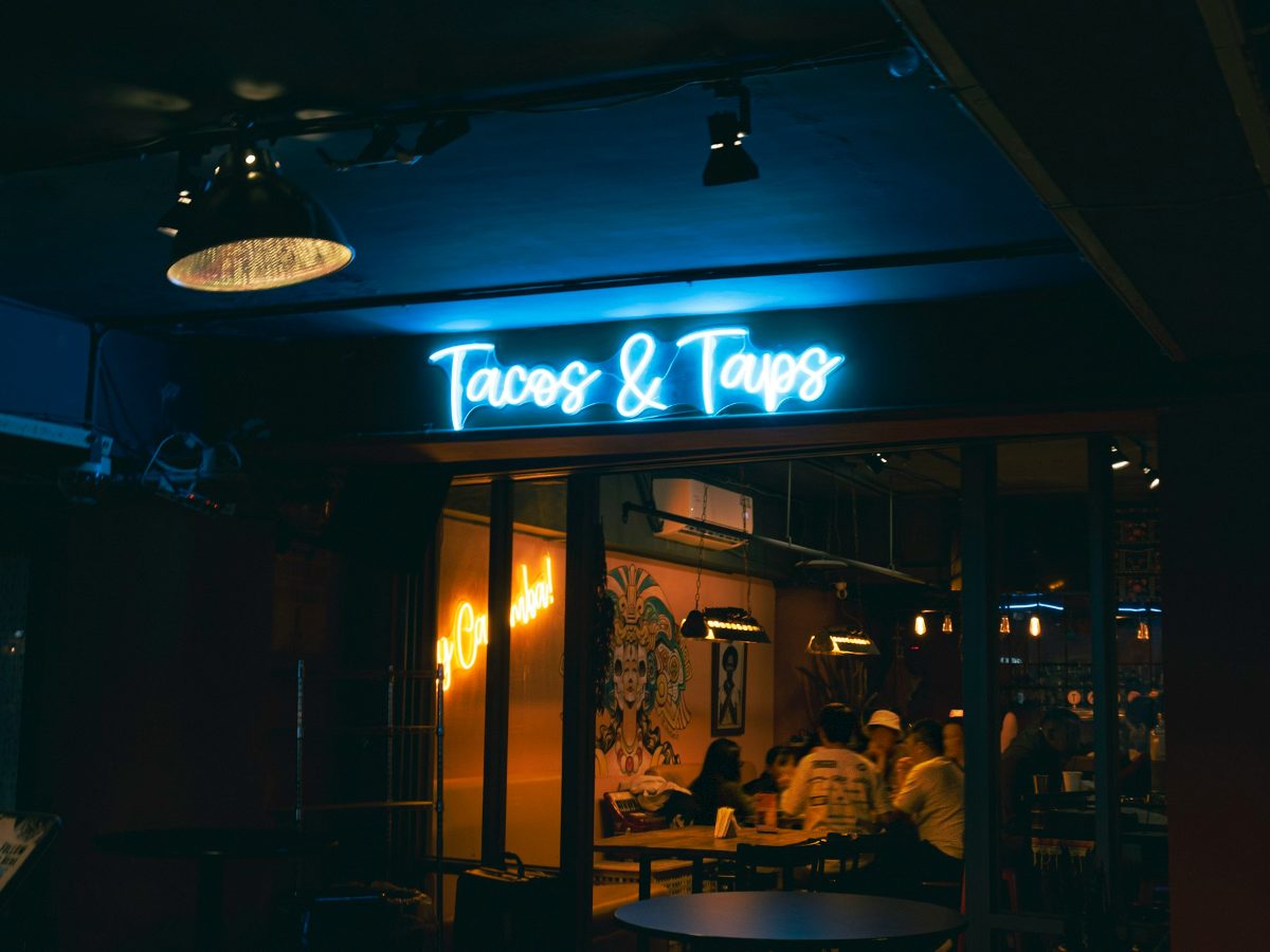A softly lit bar with stools and tables