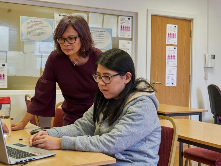 Two charity colleagues working together at a laptop