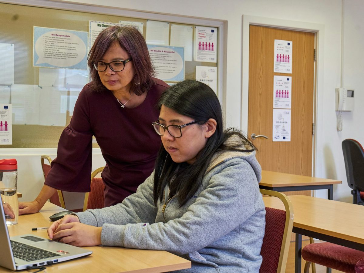 Two charity colleagues working together at a laptop