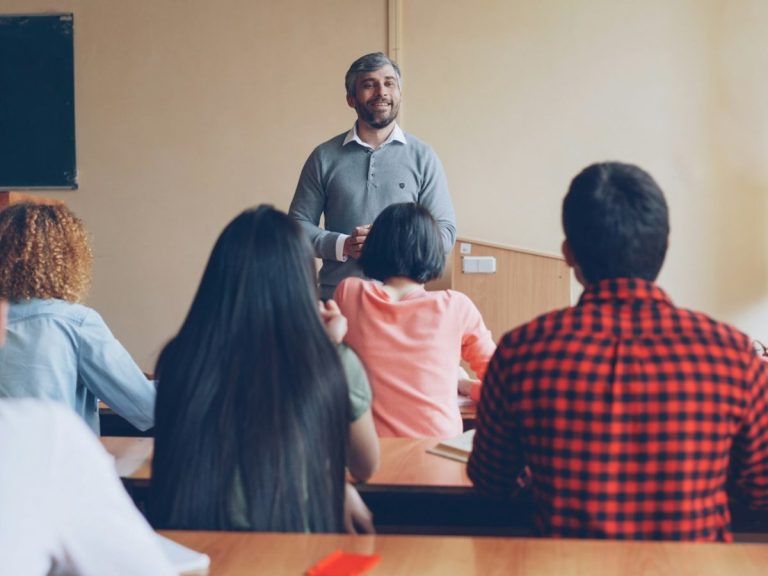 Teacher talking with students in a classroom