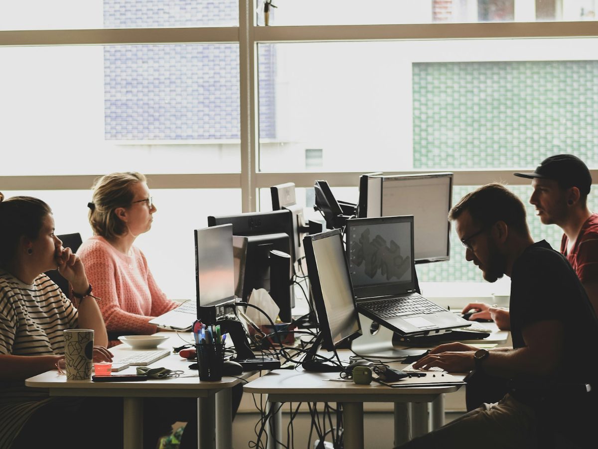 Small business team working at computers in a sunlit office